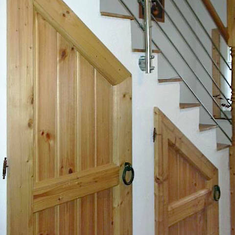 Holztüren eines maßgefertigten Einbauschranks unter der Treppe